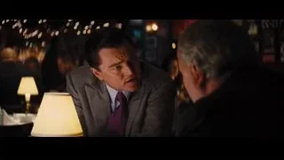 two men talking in dimly lit room — The Wolf Of Wall Street