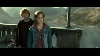 Young couple embracing on balcony overlooking mountains — Harry Potter and the Deathly Hallows 2