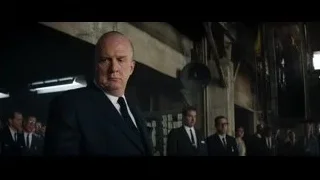 bald man in suit walking in large room — Ford v Ferrari