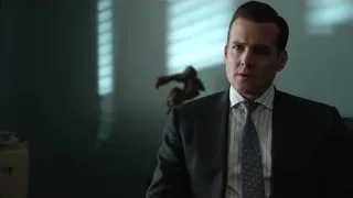 man in suit sitting in dimly lit room — Suits