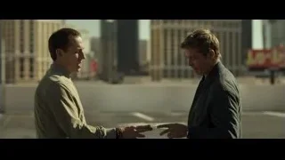 Two men conversing in empty parking lot — F1