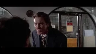 Man in suit and woman by glass door — American Psycho