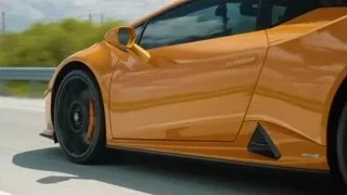 orange sports car driving fast on highway — Sports Cars