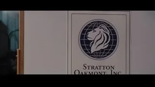 Man in suit pointing at Strategic Oakmont sign — The Wolf Of Wall Street