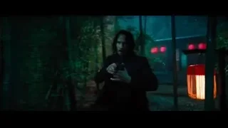 man holding gun in dimly lit garden at night — John Wick: Chapter 4