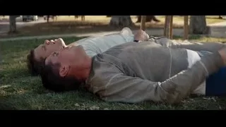 two men lying on grass — Ford v Ferrari