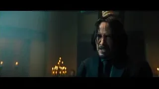 man with beard in dimly lit room with candles — John Wick: Chapter 4