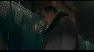 Man in beige coat leaning against lockers — Joker
