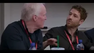 two men conversing at table — The Social Dilemma