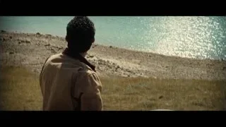 man standing in field looking at water — Interstellar