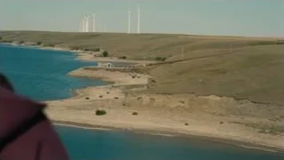 vast landscape with water and wind turbines — Interstellar
