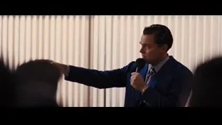 man in blue suit speaking to group — The Wolf Of Wall Street