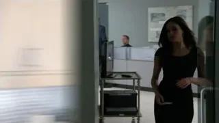 Man and woman conversing at office desk — Suits