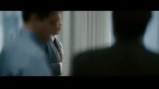 Man in suit reading book at desk — The Persuit of Happyness