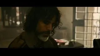 bearded man looking serious in dim room — Gladiator 2