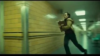 person walking down long yellow brick hallway — Joker