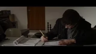 Young man writing in notebook at table — The Amazing Spider Man