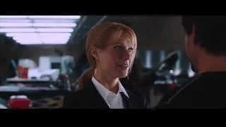 Woman and man talking in cluttered garage — Iron Man