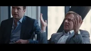 two men in suits conversing in office with windows — The Big Short