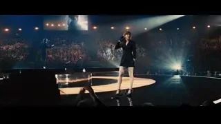 woman on stage with microphone and crowd — Now You See Me