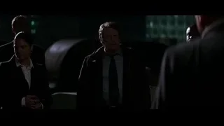man in suit holding gun in industrial setting — Batman: The Dark Knight