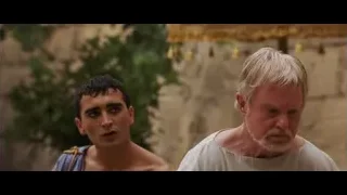 two men in robes by stone wall — Gladiator