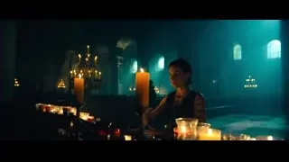 Woman at table with candles in arched room — John Wick: Chapter 4