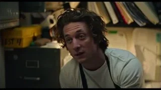 man in apron in cluttered kitchen — The Bear