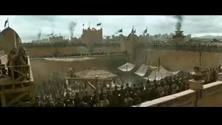 Crowd on medieval castle rooftop with fire — Gladiator 2