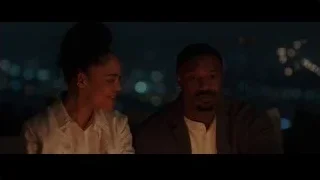 couple on bench looking at each other at night — Creed 3
