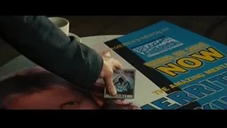 Person holding playing card with book — Now You See Me