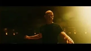 bald man standing on stage with arms stretched — Whiplash