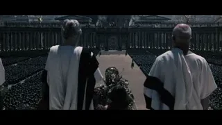 Two men in robes in front of palace crowd — Gladiator