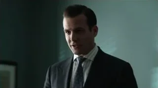 man in suit sitting in dark green room — Suits