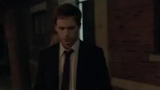 Man in black suit walking in dim hallway — Suits