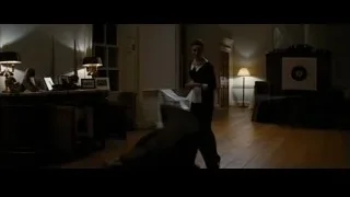 couple embracing in dimly lit room — Batman: The Dark Knight Rises