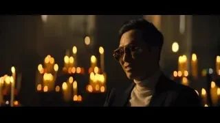 Man in suit standing before lit candles — John Wick: Chapter 4