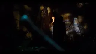 person holding torch in dark cave — Jurassic World