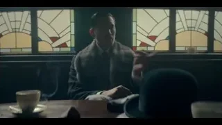 man at table in dimly lit stained glass room — Peaky Blinders