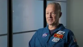 man in space suit looking at Earth — Elon Musk: Return to Space