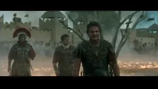 men in armor walking by burning castle — Gladiator 2