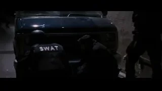 SWAT officers in riot gear in front of car — Batman: The Dark Knight Rises