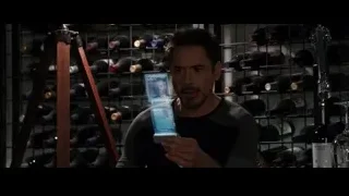 man looking at blue box in front of wine rack — Iron Man 3