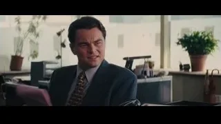 two men in office conversing at desk — The Wolf Of Wall Street