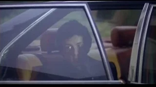 man in suit sitting in car — Rocky III