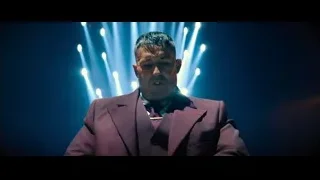 man in suit playing piano on stage — John Wick: Chapter 4