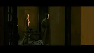 man and woman conversing in dimly lit room — Gladiator 2