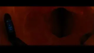 man's face peeking from red wall — The Dictator