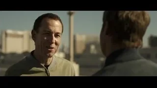 Two men talking with cityscape background — F1