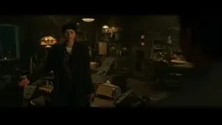 person holding suitcase in cluttered workshop — Spiderman: No Way Home
